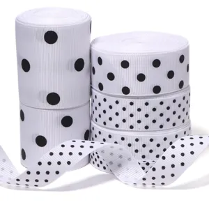 Dettaglio ravvicinato di nastri gros-grain bianchi con pois neri per confezioni regalo.