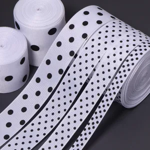 Vista dettagliata di nastri in grosgrain bianco con pois neri per fiocchi fai da te e regali.