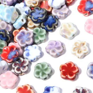 Vista dettagliata di perline di fiori in ceramica smaltata colorata per gioielli fai da te.