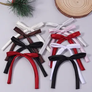 Close-up of assorted color satin ribbon bows with long tails, ideal for handmade DIY accessories.