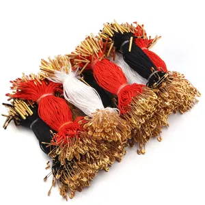 Detail view of hang tag strings with gold metal pins, red white and black threads for apparel.