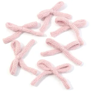 Pink knitted bow accessories, fluffy cotton yarn, sweet DIY hair clip clothing hat details.