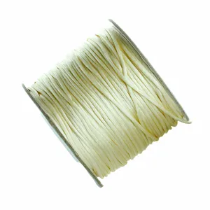 Primer plano detallado de cordón de tejido beige enrollado ordenadamente en una bobina.
