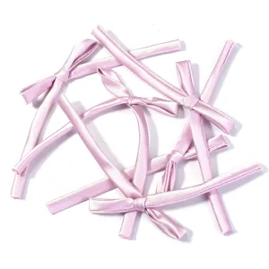 Close-up details of pink satin ribbon bows, ideal for DIY hair accessories and gift packaging.