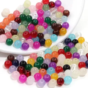 Gros plan de perles rondes en verre colorees, ideal pour accessoires de bijoux artisanaux DIY.