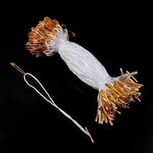 Gold safety pin tag fasteners with white nylon string for clothing hang tags and apparel accessories.