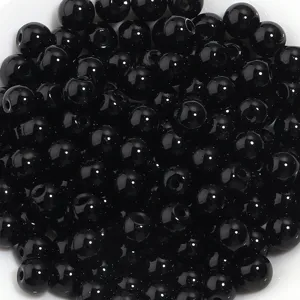 Perles rondes en verre noir gros plan detail, parfaites pour la creation de bijoux DIY.