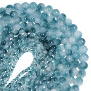 Primo piano di perline in calcedonio blu, elegante disposizione a spirale per gioielli fai da te.