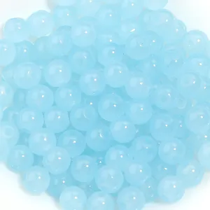 Gros plan de perles rondes en verre bleu clair pour fabrication de bijoux et accessoires.