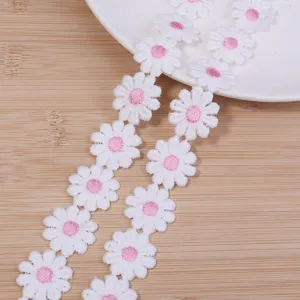 Detalle de ribete bordado margarita blanco rosa, ideal para accesorios de pelo y ropa.
