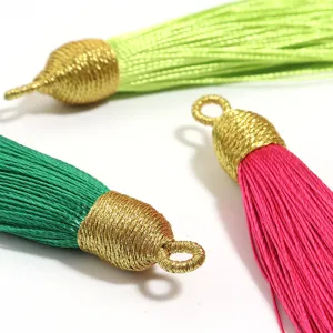 Primo piano dettagliato di nappe fai-da-te colorate con cappucci dorati per artigianato creativo.