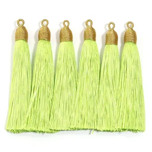Vista dettagliata di nappe artigianali verde chiaro con anelli dorati per accessori.