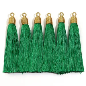 Vista dettagliata di nappe verdi con anelli dorati avvolti, perfette per creazioni fai da te.