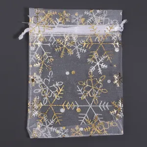 Sacchetto regalo in organza bianca con coulisse e motivi di fiocchi di neve oro e argento.