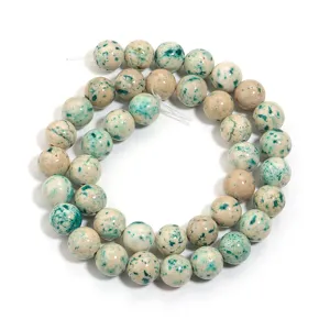Dettaglio di perline rotonde in pietra naturale con motivo verde per accessori fai da te.