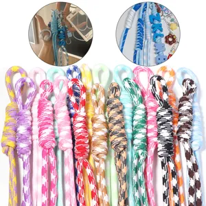 Detailed view of colorful hand-woven nylon rope bag charms and keychains with custom letter beads.