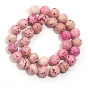 Perline tonde rosa screziate in pietra naturale per creazione di gioielli fai da te.