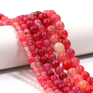 Red cracked agate beads detail close up, shiny dragon vein gemstone jewelry components.