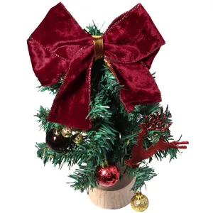 Vista detallada de mini árbol de navidad con gran lazo de terciopelo rojo y adornos.