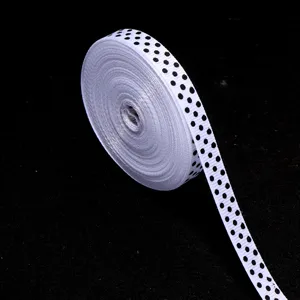 Dettaglio nastro grosgrain a pois neri e bianchi per confezione regalo e lavori artigianali.