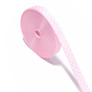 Primo piano dettagliato di nastro gros-grain a pois rosa, ideale per fai-da-te e confezioni.