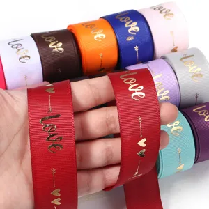Detailed view of colorful polyester grosgrain ribbons featuring gold foil love and heart print.