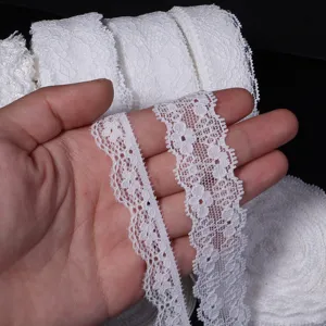 Dettaglio bordo in pizzo elastico bianco, delicato motivo floreale per abito da sposa e cucito.