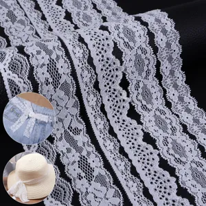 Dettaglio del pizzo elastico bianco con motivi floreali intricati per lavori di cucito.