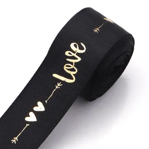 Black ribbon with gold foil love print for gift wrapping and DIY crafts detail view.