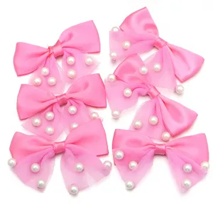 Pink ribbon mesh bow with faux pearl embellishments, detailed view of DIY accessories.