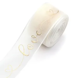 Detailansicht von weißem Organzaband mit goldenem Love-Druck für Geschenke und Dekoration.