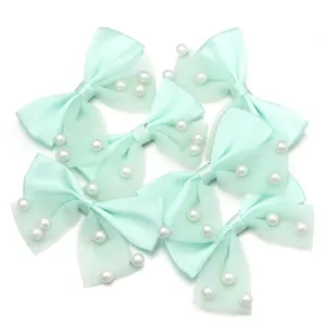 Mint green mesh ribbon bows with pearls for DIY hair clips and clothing accessories.