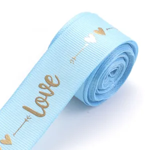Light blue ribbon detail with gold foil love and heart pattern for DIY gift wrap.