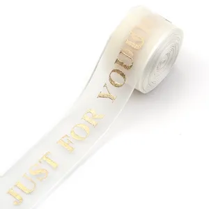 Weißes transparentes Organzaband mit Goldfoliendruck, ideal für Geschenkverpackungen.