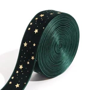 Dark green velvet ribbon roll featuring gold foil stars detail for DIY crafts and party decor.