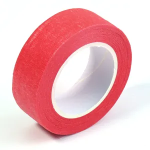 Vue rapprochée du rouleau de ruban de masquage rouge vif avec texture papier visible.