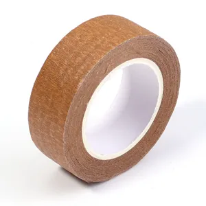 Vue détaillée de ruban de masquage marron avec surface adhésive texturée et structure en rouleau.