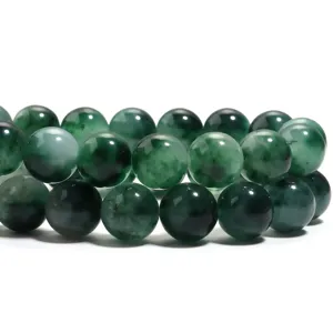 Vista dettagliata di perline tonde in calcedonio verde con eleganti macchie scure e superficie liscia.