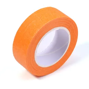 Gros plan détaillé du rouleau de ruban de masquage orange montrant la texture du papier.