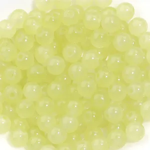 Gros plan détaillé de perles rondes en verre translucide vert clair pour bijoux DIY.