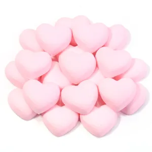 Detailopname van roze hartvormige PVC zachtrubberen DIY accessoires voor telefoonhoesjes en haarspelden.