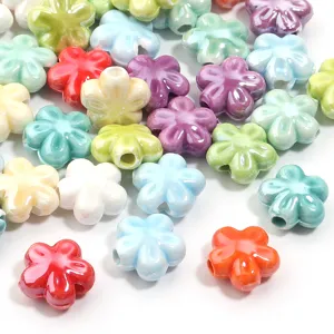 Dettaglio di perline di fiori in ceramica, distanziatori smaltati colorati per gioielli fai da te.