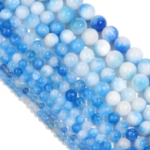 Primo piano di perline rotonde in calcedonio blu, accessori per gioielli fai da te.