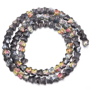 Nahaufnahme von galvanisierten Glasperlen in Schmetterlingsform für Schmuckherstellung.