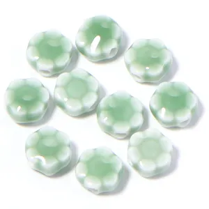 Dettaglio di perline di fiori di margherita in ceramica, ideale per gioielli DIY e bracciali.