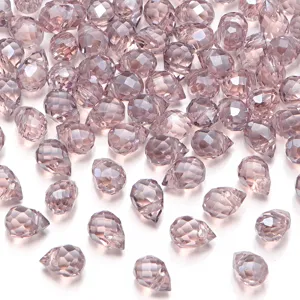 Detailweergave van iriserende glazen gefacetteerde kristalparels met gaten voor sieraden.