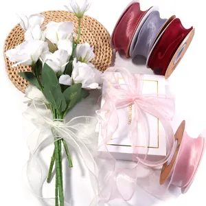 Organza lint rollen en witte bloemenboeket voor cadeoverpakking en DIY knutselen.