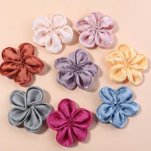 Detailed shot of glossy satin five-petal fabric flowers, perfect for DIY hair clips.