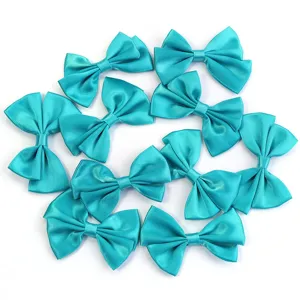 Vue détaillée de nœuds en satin turquoise, accessoires DIY double couche pour pinces à cheveux.