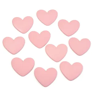 Close-up detail of pink heart resin flatback patch for DIY phone cases and hair accessories.